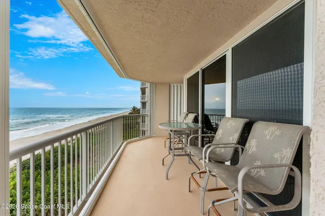 a view of a patio with lawn chairs under an umbrella