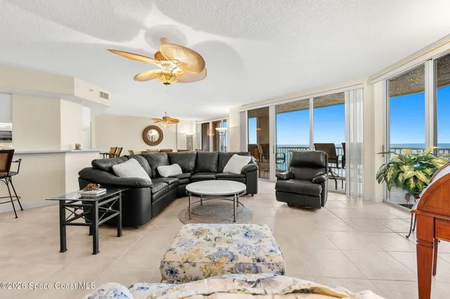 a living room with furniture kitchen view and a wooden floor