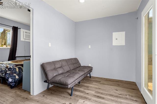 605 Huron Road Colorado Springs, CO 80910 - Photo 17 of 30 Living area with wood finished floors, a wall mounted AC, recessed lighting, and electric panel