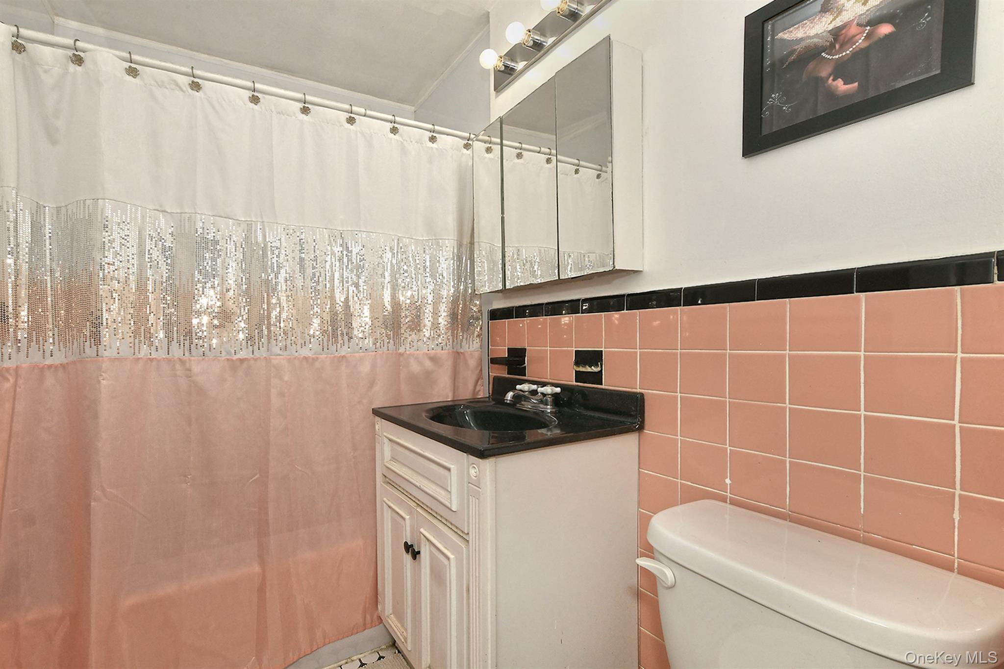 63-05 138th Street Queens, NY 11367 - Photo 13 of 22 Bathroom featuring vanity, tile walls, a shower with shower curtain, and wainscoting