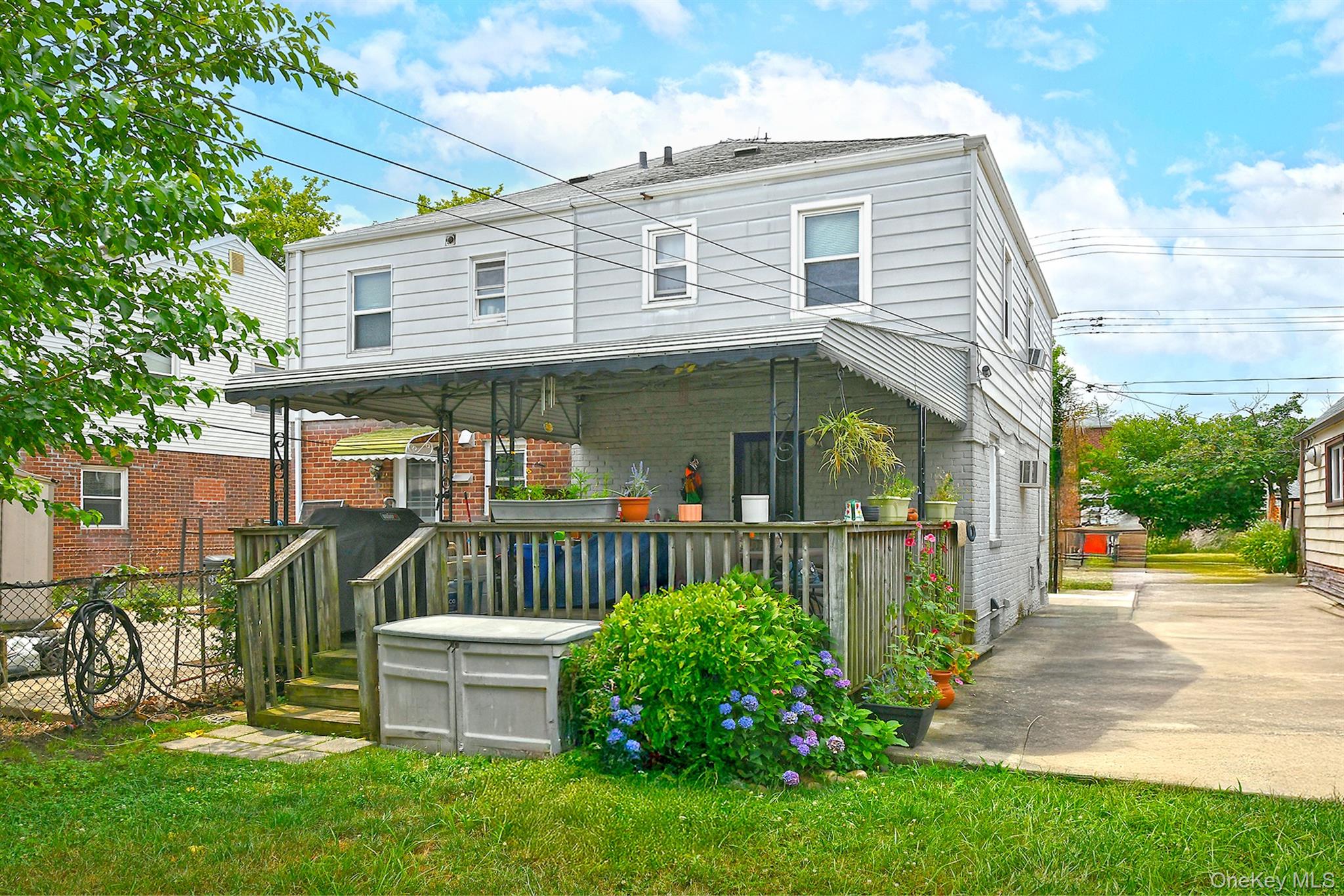 63-05 138th Street Queens, NY 11367 - Photo 21 of 22 Rear view of property featuring brick siding and a wooden deck