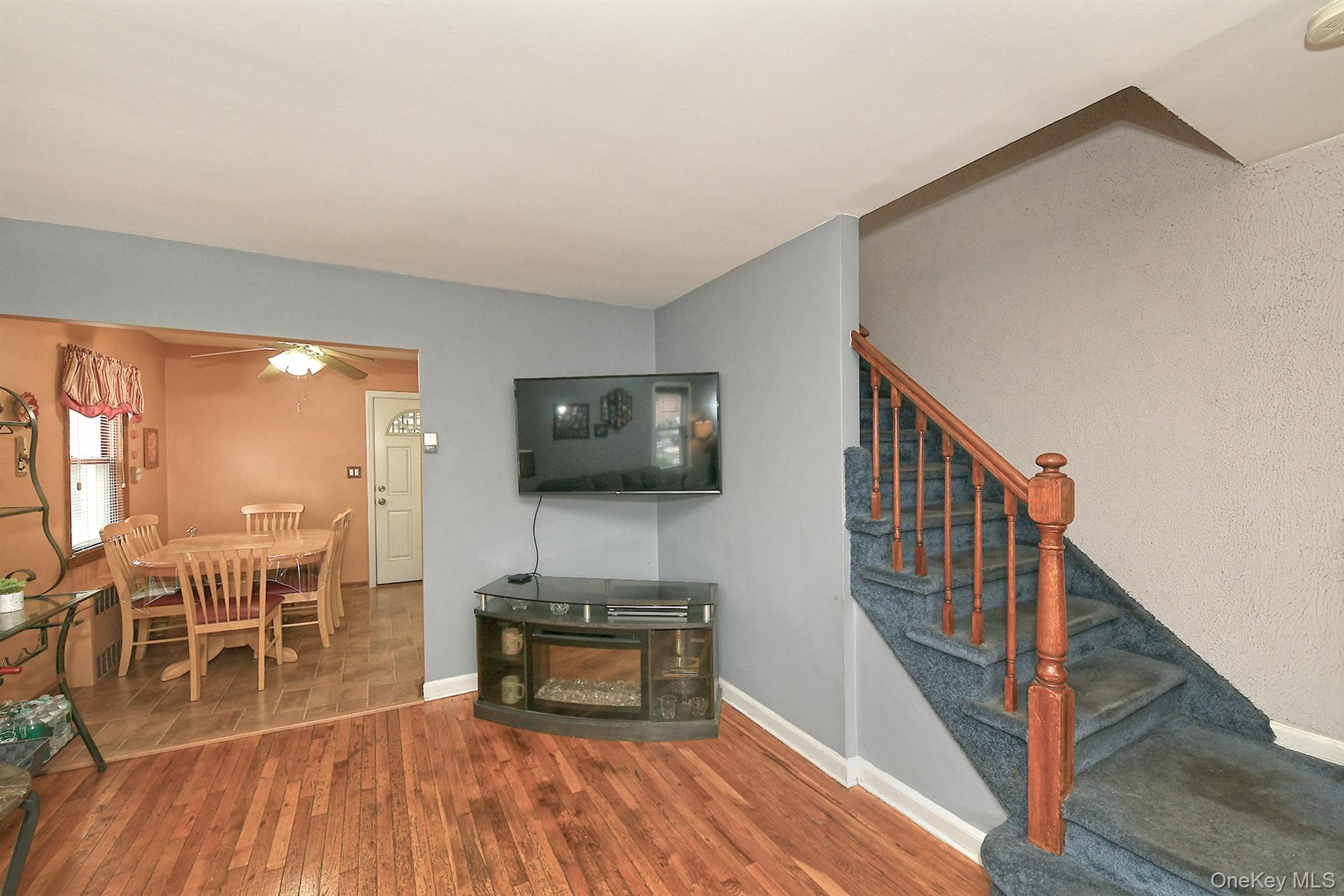 63-05 138th Street Queens, NY 11367 - Photo 5 of 22 Living room featuring wood finished floors, stairs, and a ceiling fan