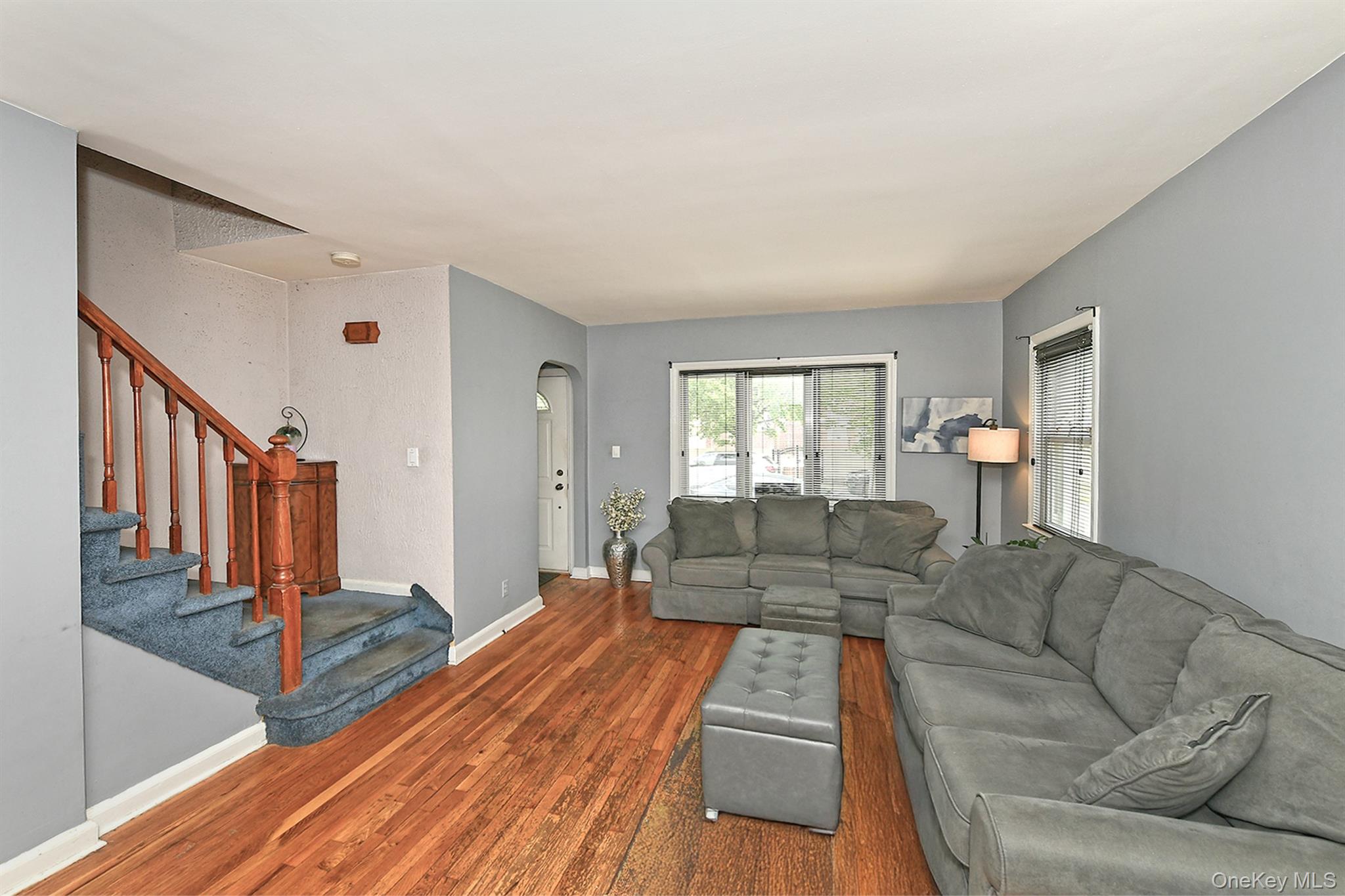 63-05 138th Street Queens, NY 11367 - Photo 7 of 22 Living area featuring wood finished floors, stairs, and arched walkways