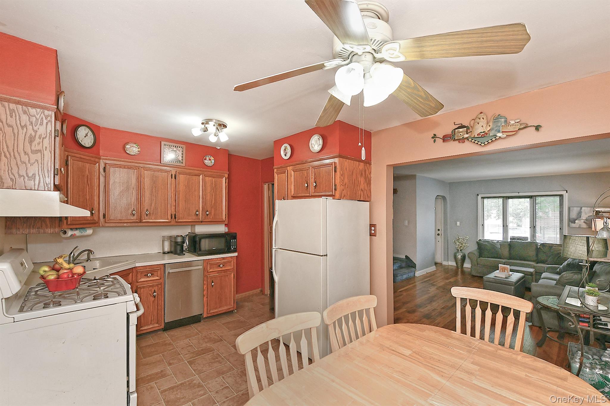 63-05 138th Street Queens, NY 11367 - Photo 22 of 22 Kitchen featuring white appliances, brown cabinetry, ceiling fan, exhaust hood, and open floor plan