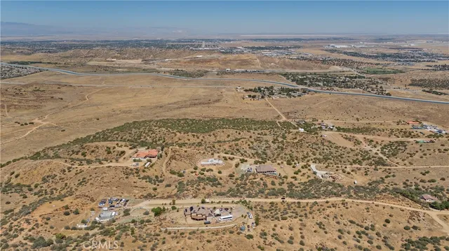 an aerial view of house with yard and mountain view in back