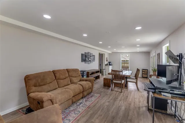 a living room with furniture a flat screen tv and wooden floor