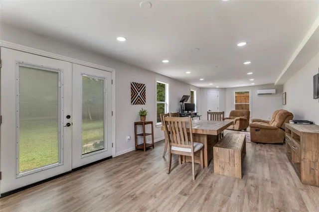 a living room with furniture a wooden floor and next to a window