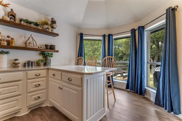 a kitchen with stainless steel appliances granite countertop a stove a sink and a refrigerator with wooden floor