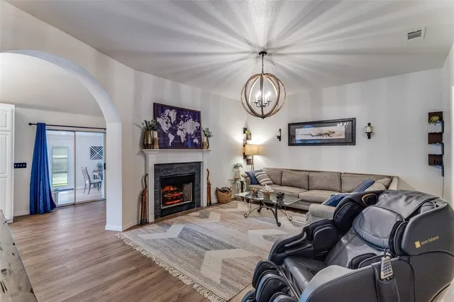 a living room with furniture a fireplace and wooden floor
