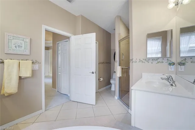 a en suite bathroom with a granite countertop sink a mirror and a shower