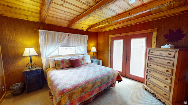 315 Abbey Road Moab, UT 84532 - Photo 26 of 46 Bedroom featuring french doors, light colored carpet, wooden walls, and a wood ceiling with exposed beams
