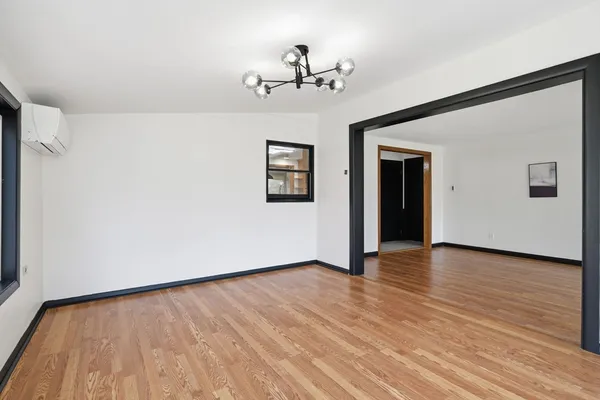 a view of a big room with wooden floor and windows