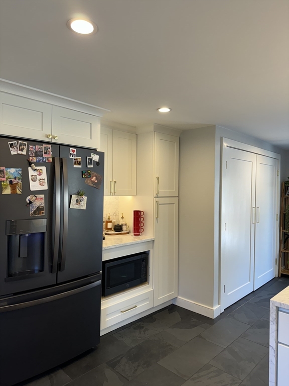 173 Guildford Road Barnstable, MA 02632 - Photo 6 of 26 a view of a refrigerator in kitchen and an empty room with wooden floor