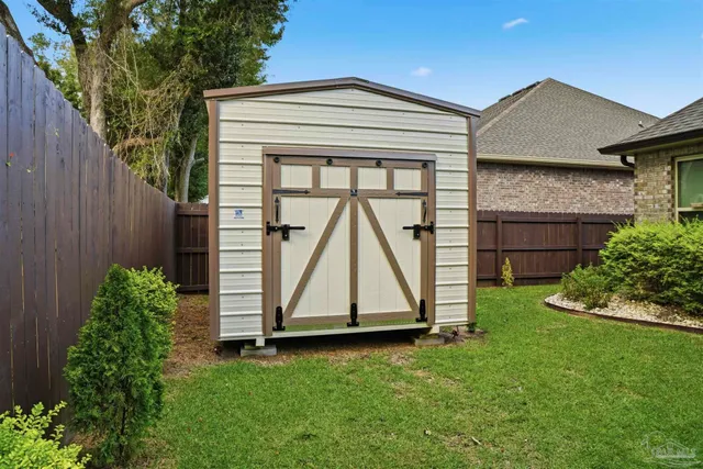 a view of backyard with a tub and wooden fence