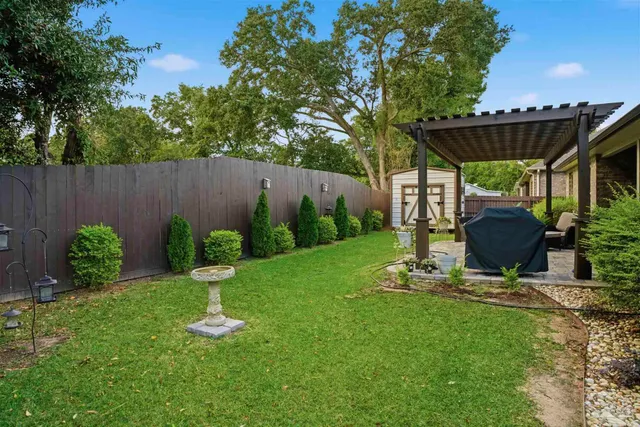 a view of a backyard with table and chairs potted plants and wooden fence