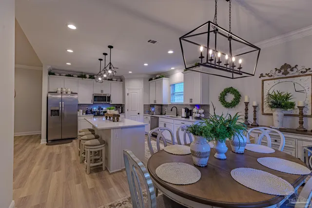 a kitchen with stainless steel appliances kitchen island granite countertop stainless steel appliances a table and chairs in it