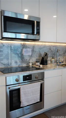 a stove top oven sitting inside of a kitchen