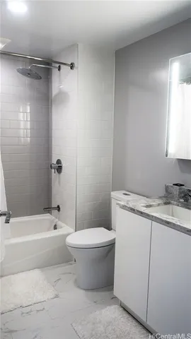 a bathroom with a granite countertop toilet a sink and bathtub