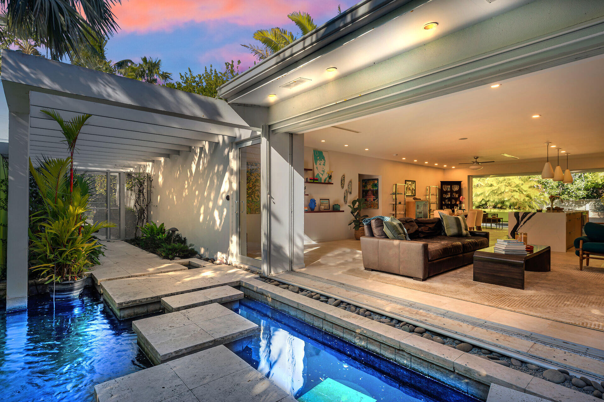 a living room with patio furniture and a potted plant