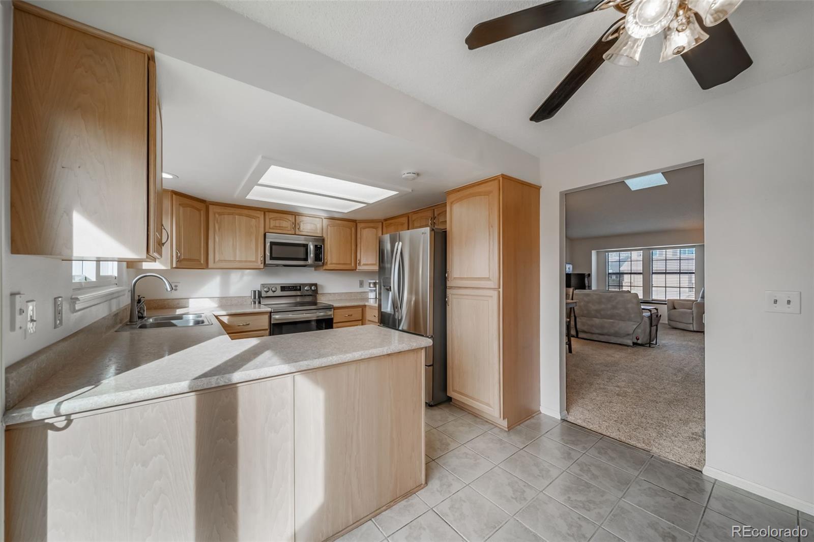 9240 Stargrass Circle Highlands Ranch, CO 80126 - Photo 15 of 46 a kitchen with stainless steel appliances a refrigerator and a stove top oven