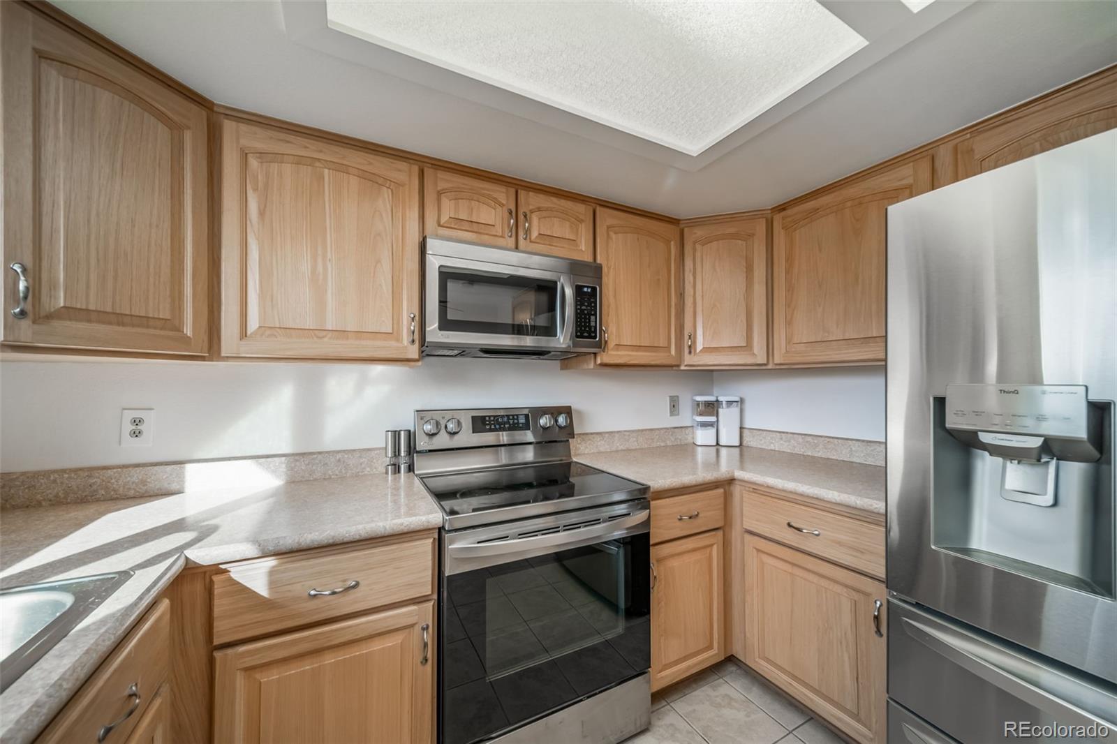 9240 Stargrass Circle Highlands Ranch, CO 80126 - Photo 18 of 46 a kitchen with stainless steel appliances granite countertop a refrigerator stove a sink and dishwasher with wooden floor