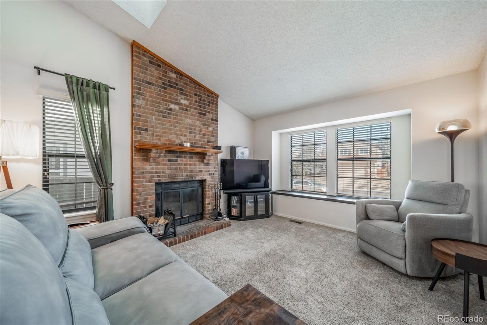 9240 Stargrass Circle Highlands Ranch, CO 80126 - Photo 7 of 46 a living room with furniture a fireplace and a flat screen tv