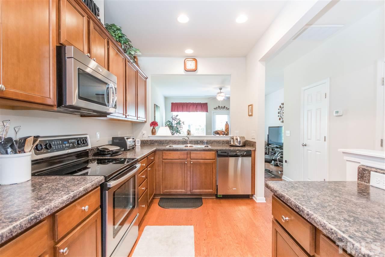 2960 Berkeley Springs Place Raleigh, NC 27616 - Photo 6 of 14 a kitchen with stainless steel appliances granite countertop a stove a sink and a microwave