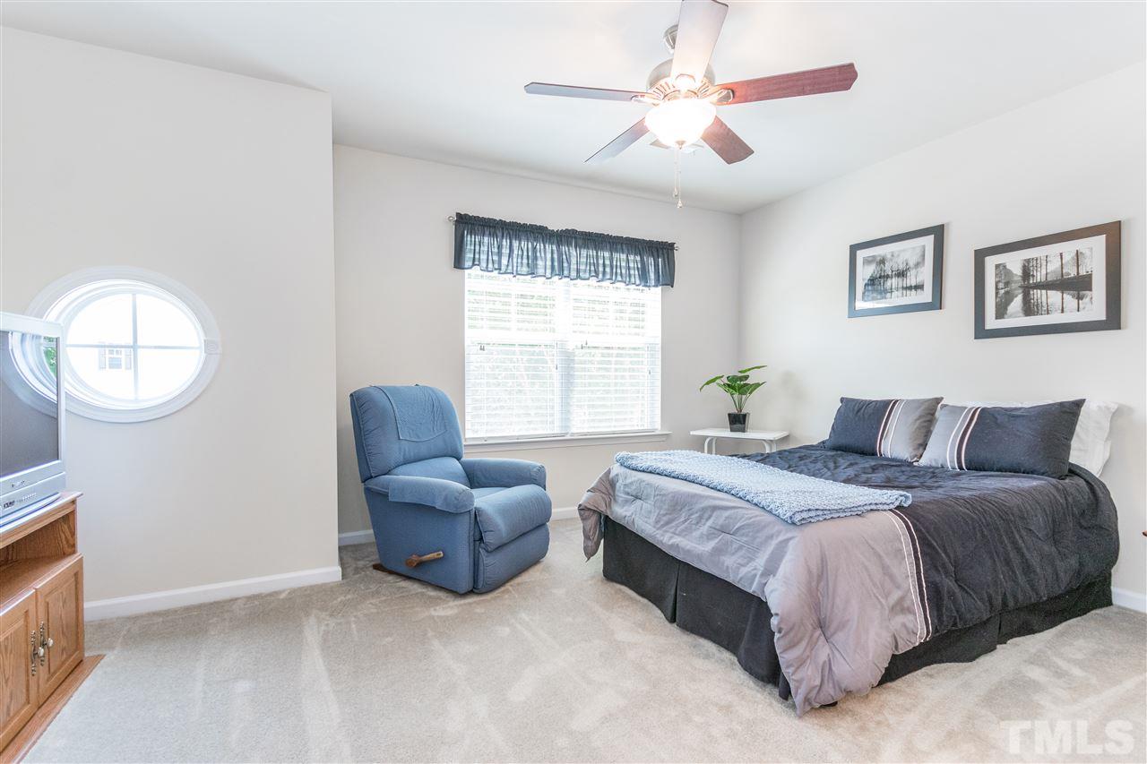 2960 Berkeley Springs Place Raleigh, NC 27616 - Photo 10 of 14 a spacious bedroom with a bed a couch and a large window