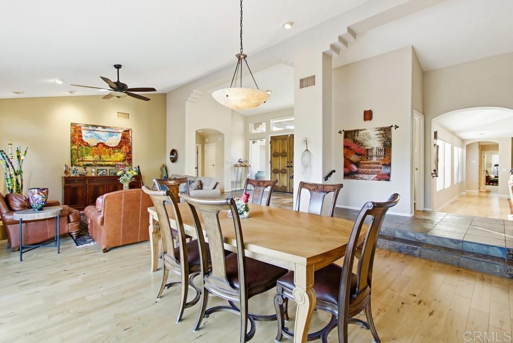 3930 Via Palo Verde Lago Alpine, CA 91901 - Photo 25 of 75 a dining room with wooden floor a chandelier a wooden table and chairs