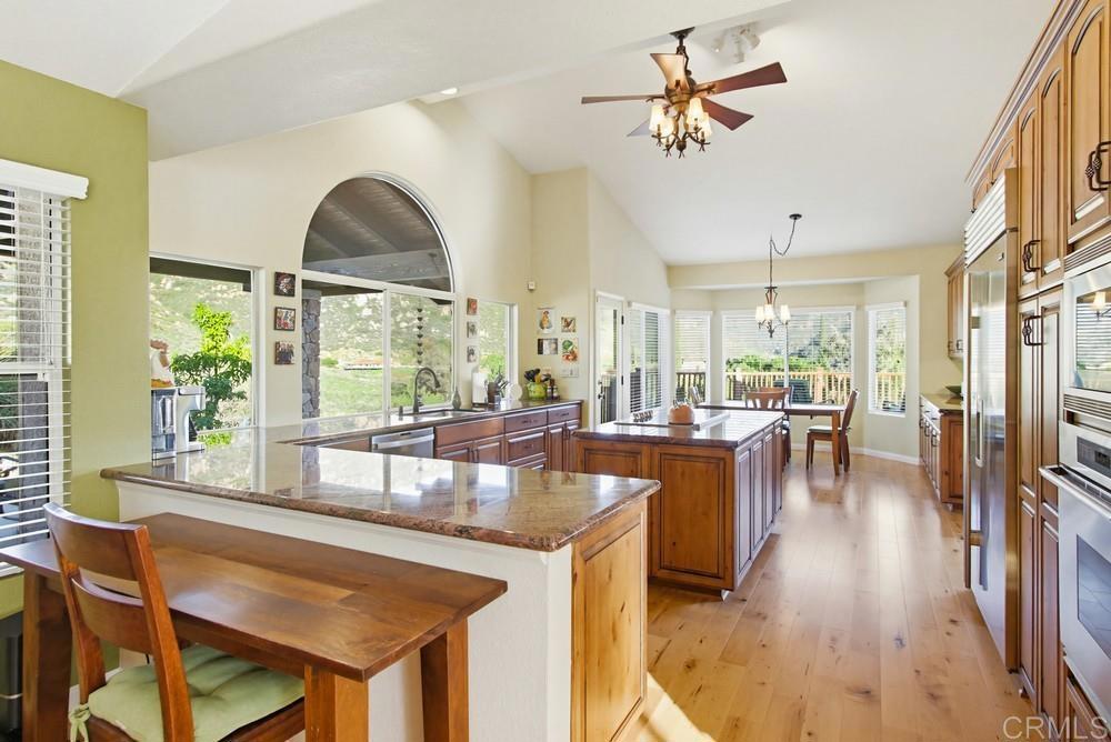 3930 Via Palo Verde Lago Alpine, CA 91901 - Photo 35 of 75 a dining hall with stainless steel appliances granite countertop a stove a refrigerator a dining table and chairs with wooden floor