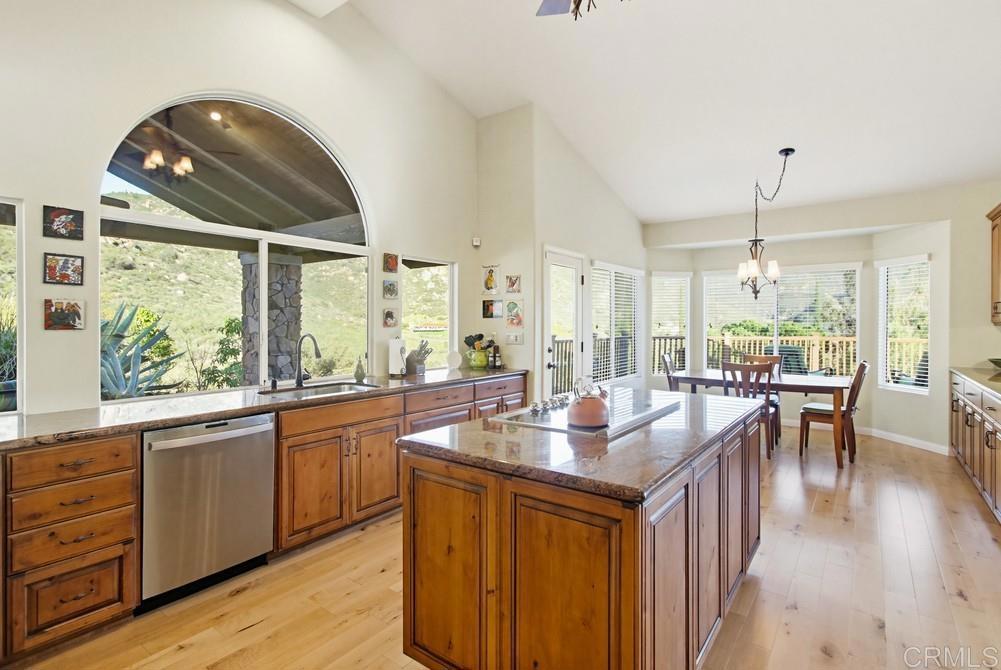 3930 Via Palo Verde Lago Alpine, CA 91901 - Photo 36 of 75 an open kitchen with granite countertop a stove dining table chairs and a large window