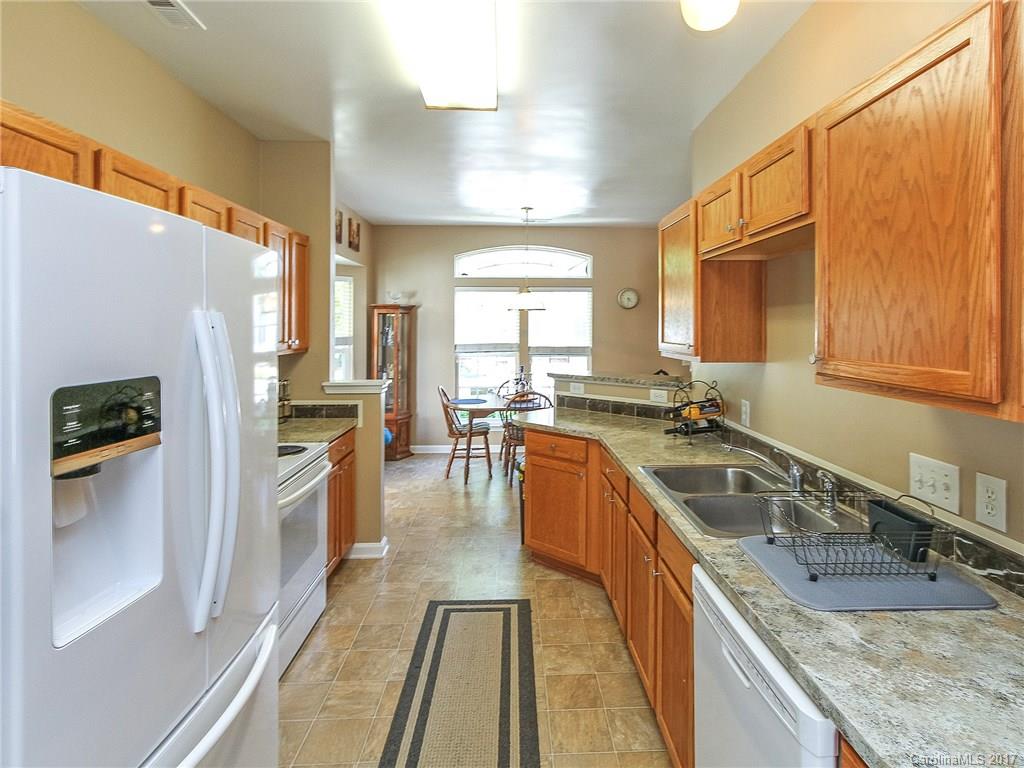 853 Dillard Road, Unit 103 Rock Hill, SC 29730 - Photo 6 of 18 a kitchen with granite countertop a sink stove refrigerator and cabinets