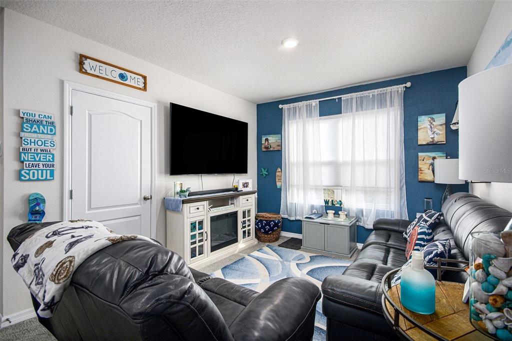 3027 Beau Loop Tavares, FL 32778 - Photo 17 of 30 a living room with furniture and a flat screen tv