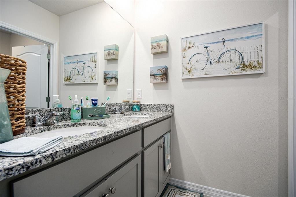3027 Beau Loop Tavares, FL 32778 - Photo 18 of 30 a bathroom with a granite countertop sink and a mirror