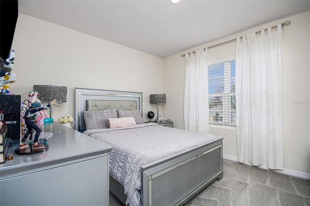 3027 Beau Loop Tavares, FL 32778 - Photo 24 of 30 a bedroom with a bed and a window