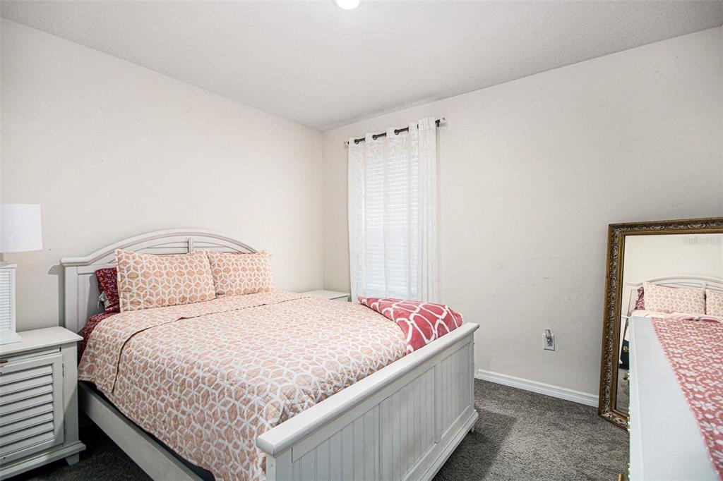 3027 Beau Loop Tavares, FL 32778 - Photo 25 of 30 a bedroom with a bed and a window