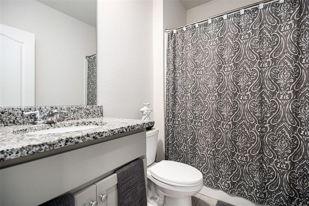 3027 Beau Loop Tavares, FL 32778 - Photo 27 of 30 a bathroom with a granite countertop sink and a toilet