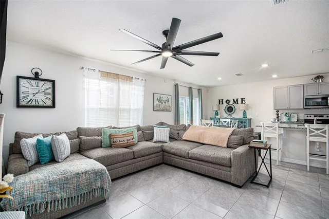 a living room with furniture a ceiling fan and a rug