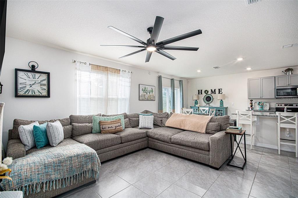 3027 Beau Loop Tavares, FL 32778 - Photo 5 of 30 a living room with furniture a ceiling fan and a rug