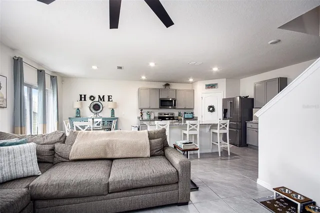 a living room with furniture and view of kitchen