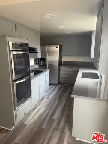 a kitchen with granite countertop a refrigerator and a sink