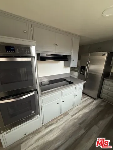 a kitchen with granite countertop white cabinets and stainless steel appliances