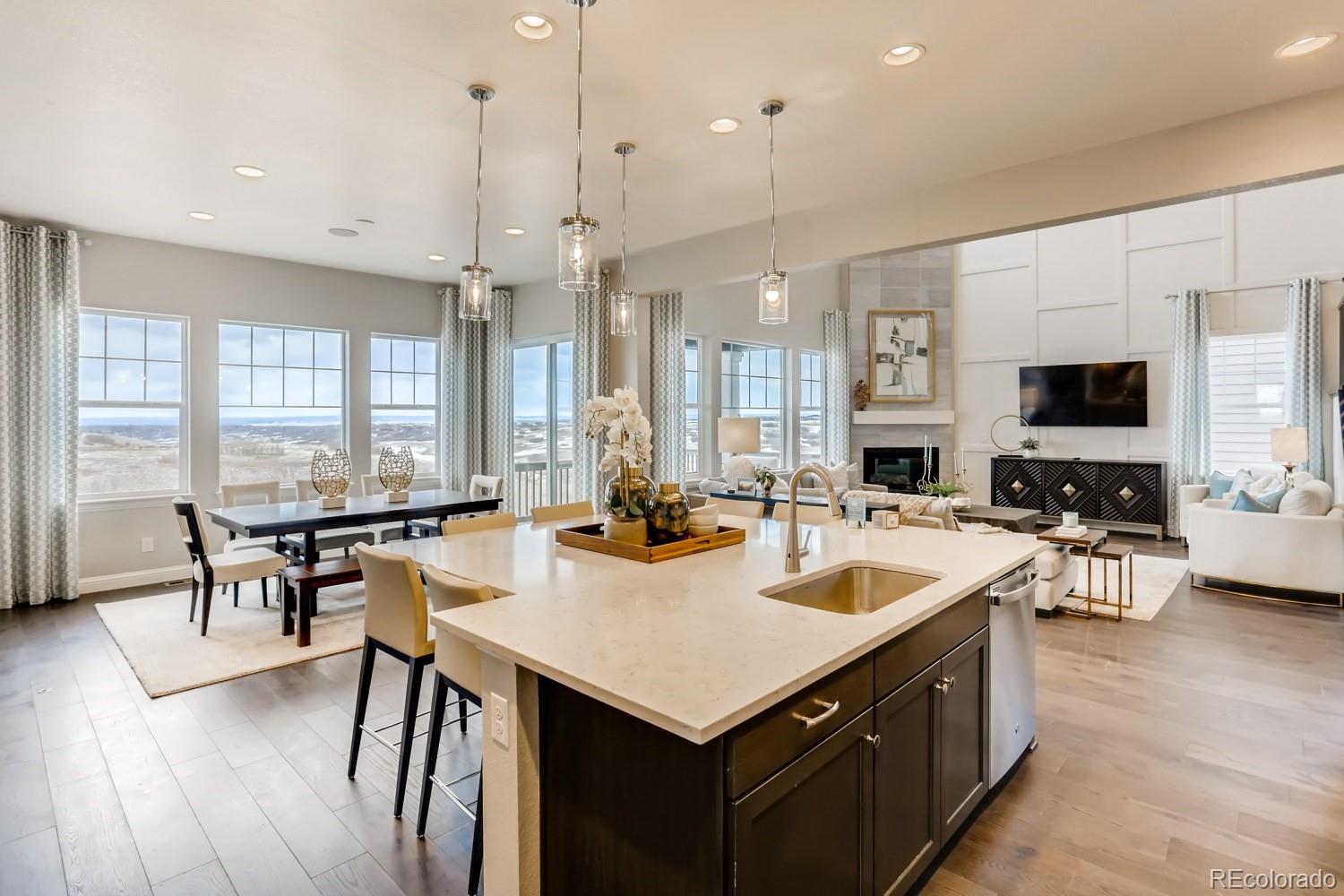 3008 Blithe Point Castle Rock, CO 80108 - Photo 11 of 29 a kitchen with a stove a kitchen island a sink and chairs