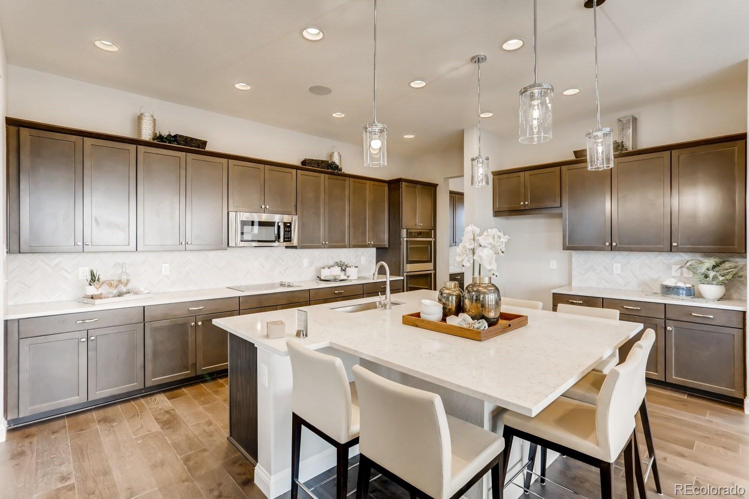 3008 Blithe Point Castle Rock, CO 80108 - Photo 8 of 29 a kitchen with a dining table chairs sink and microwave