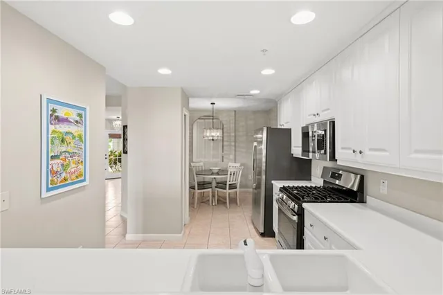 a kitchen with stainless steel appliances granite countertop a refrigerator and a stove top oven