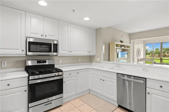 a kitchen with granite countertop white cabinets and appliances