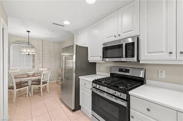 a kitchen with stainless steel appliances granite countertop a stove a refrigerator and a microwave