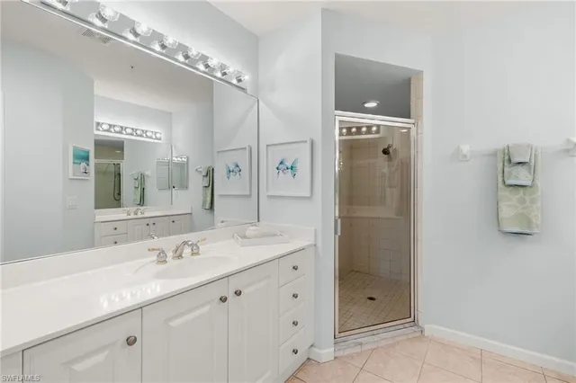 a bathroom with a double vanity sink mirror and shower