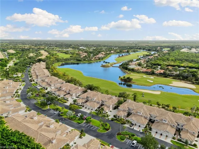 an aerial view of a city with lots of residential buildings ocean and mountain view in back