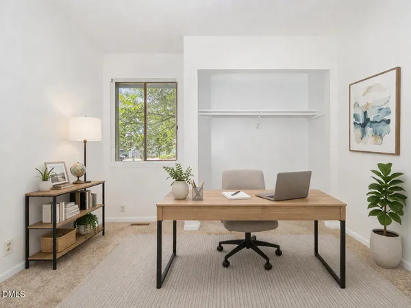 a spacious bedroom with a bed and a potted plant